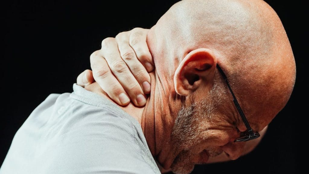 pexels-photo-7298867 Side view of senior man holding neck with visible discomfort, highlighting neck pain relief.